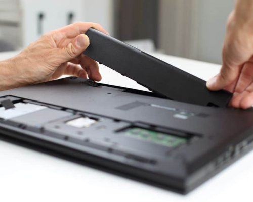 Technician Changing a Laptop Battery — Computer Repairs in Coomera